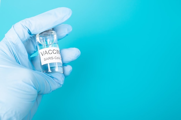 Vaccination covid19 for immunity against disease bottles of ampoule with coronavirus vaccine in the hands of a doctor in medical gloves