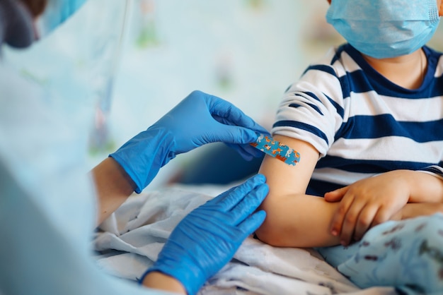 Photo vaccination of little child at home.