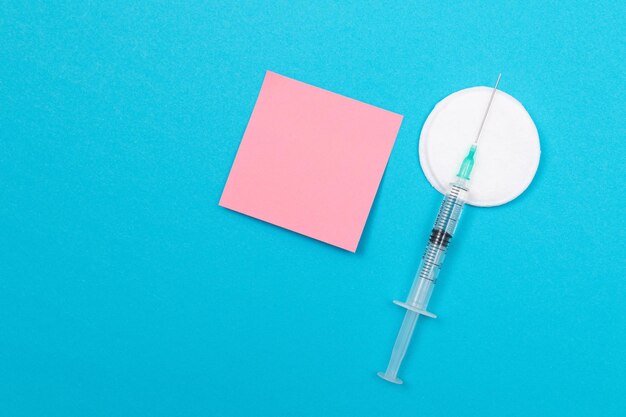 Photo vaccination or revaccination concept a medical syringe on blue table