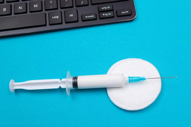 Vaccination or revaccination concept  a medical syringe on blue table