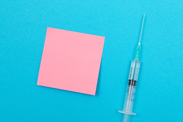 Photo vaccination or revaccination concept  a medical syringe on blue table