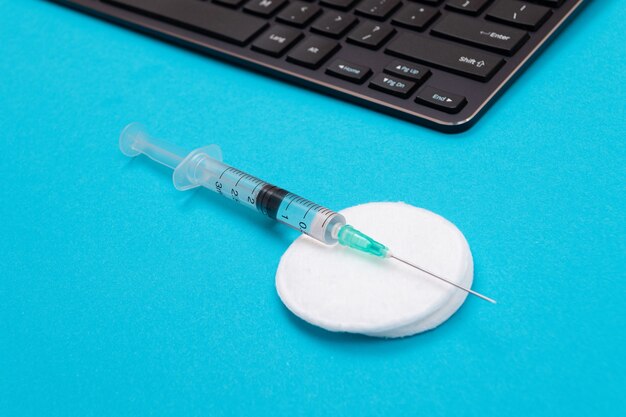 Vaccination or revaccination concept  a medical syringe on blue table