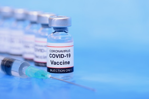사진 백신 및 의료 의료 개념. 예방을 위해 파란색 배경에 백신 및 주사기
