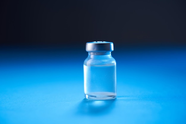 Vaccine bottle on the blue background