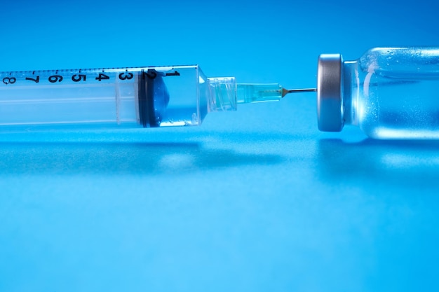 Photo vaccine bottle on the blue background