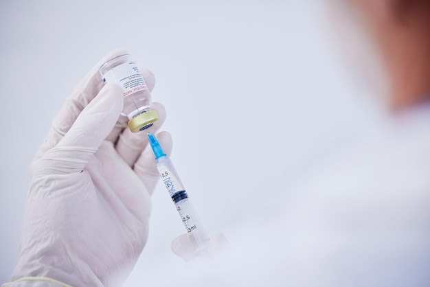 vaccine bottle needle and hands of doctor for safety healthcare and pharmaceutical medicine closeup virus injection and nurse prepare vaccination with vial medical drugs and immunity in clinic