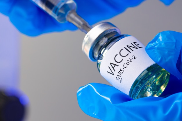 vaccine bottle with a syringe taking the vaccine from it