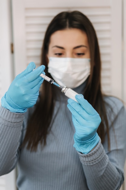 Vaccine in hands female doctor holds syringe and bottle with covid vaccine for coronavirus cure