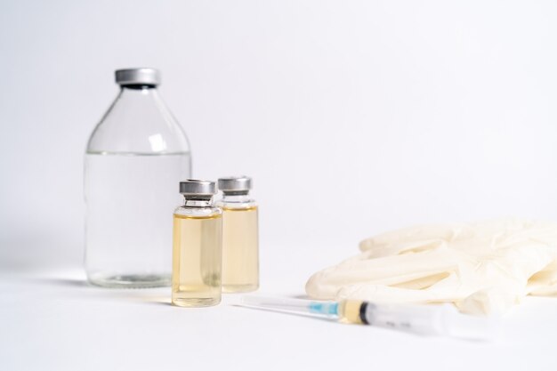 Vaccine and medical masks on a white table.