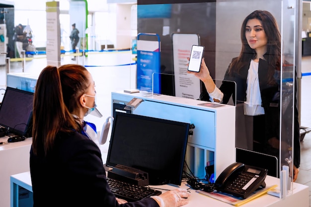 Foto controllo del passaporto del vaccino da parte del personale di terra al terminal dell'aeroporto