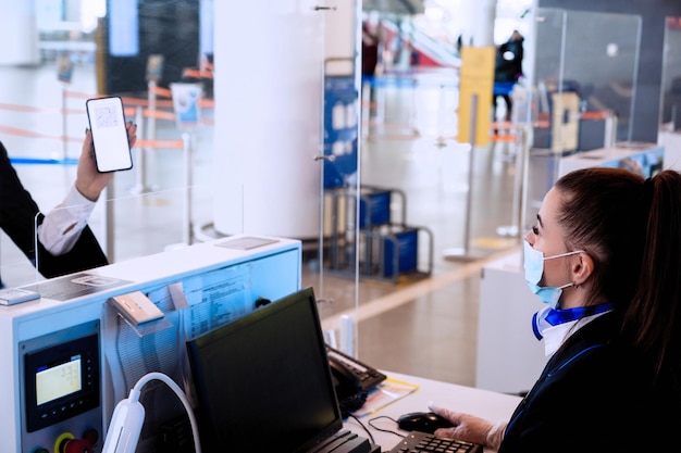 Foto controllo del passaporto del vaccino da parte del personale di terra al terminal dell'aeroporto