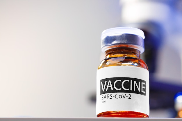 Флакон с вакциной Sars-cov-2 на столе в лаборатории