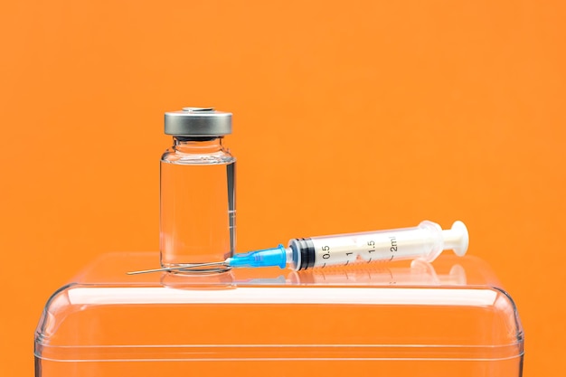 Photo vaccine with syringe on orange background