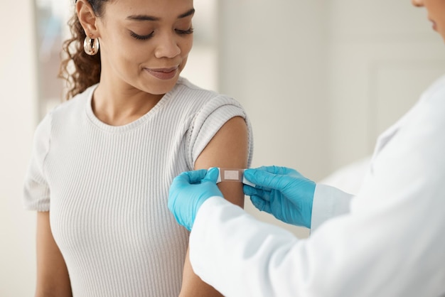 Vaccine woman and hands of doctor with plaster for health wellness and injection in clinic Healthcare patient or specialist in hospital for immune system strength illness prevention or flu shot