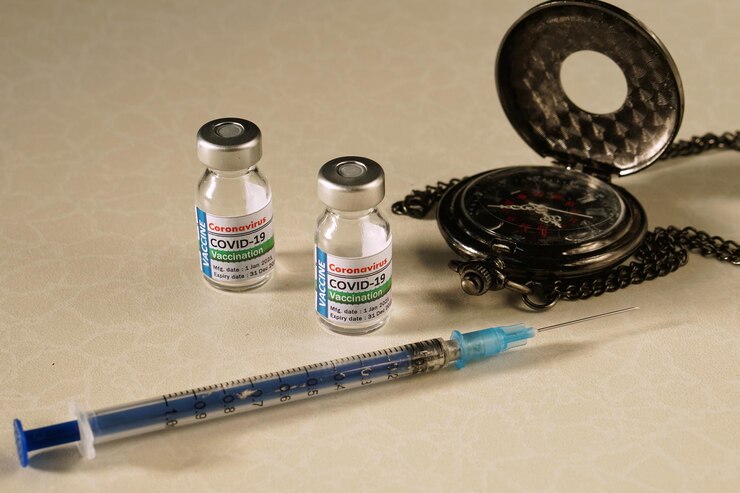 Photo vaccines syringe and watch on white table