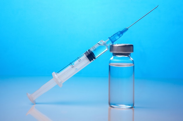 Vaccines and syringes on wooden table