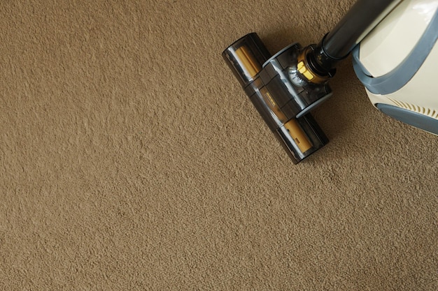 Vacuum cleane nozzle on the carpet Space for textCloseup