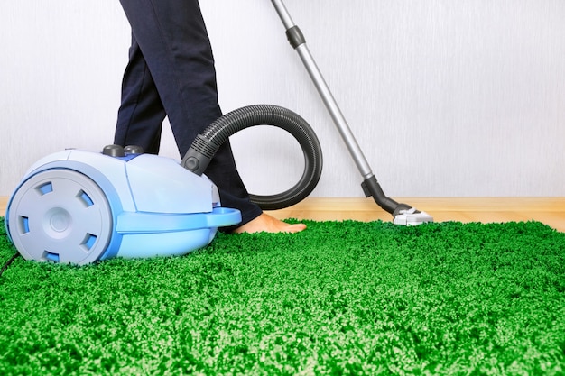 Vacuum cleaner in action   a men cleaner a carpet