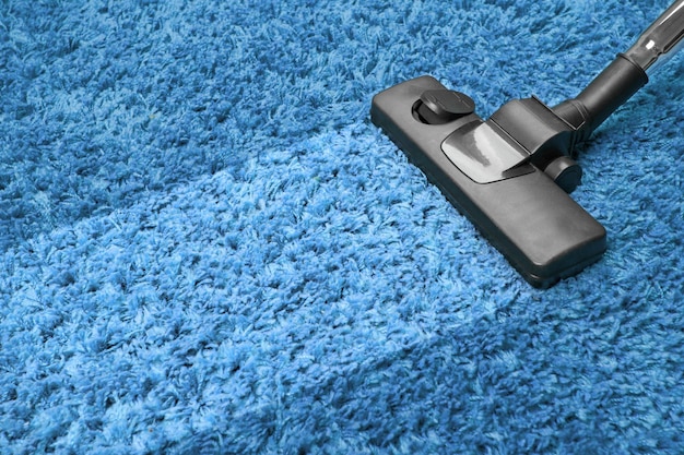 Photo vacuum cleaner on the blue carpet