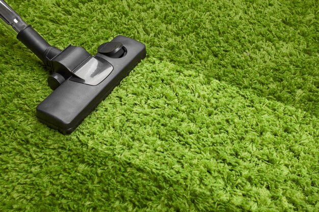 Vacuum cleaner on green carpet