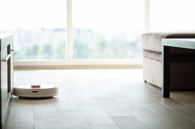 Vacuum cleaner robot runs on wood floor in a living room