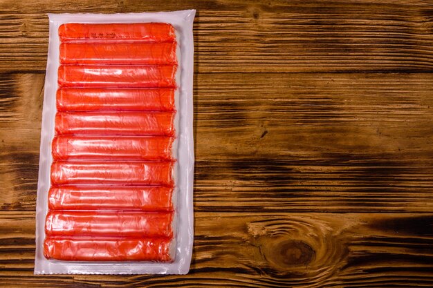 Vacuum pack of crab sticks on a wooden table Top view