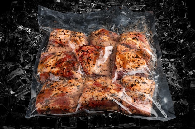 Мясо в вакуумной упаковке на фоне темного льда Стейк из свинины Полуфабрикаты