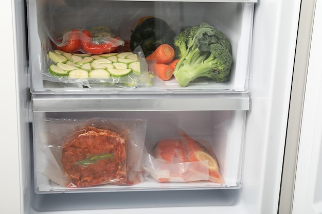 Vacuümzakken met verschillende producten in koelkast Voedselopslag