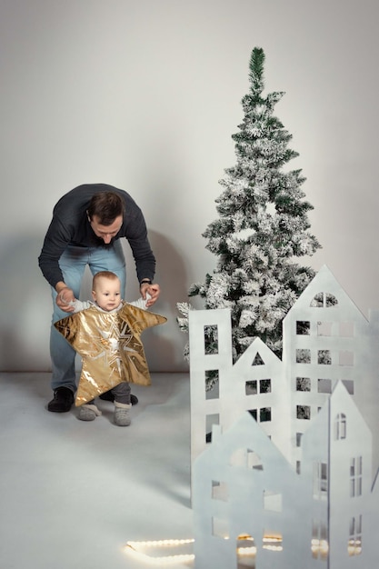 vader die de baby vasthoudt als de top van de boom