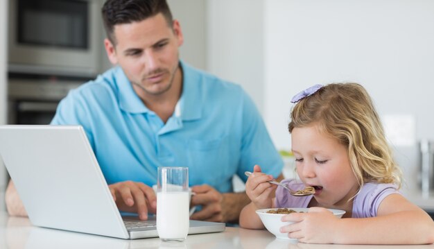 Vader die dochter bekijkt die ontbijt heeft