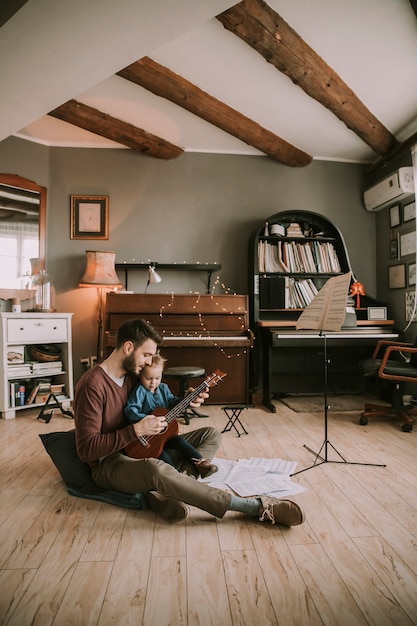 Vader die dochter onderwijzen om gitaar thuis in de ruimte te spelen