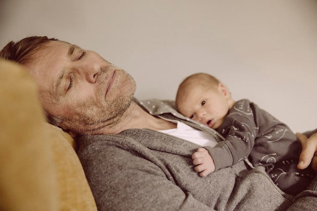 Vader die een dutje doet met pasgeboren wakker op zijn borst