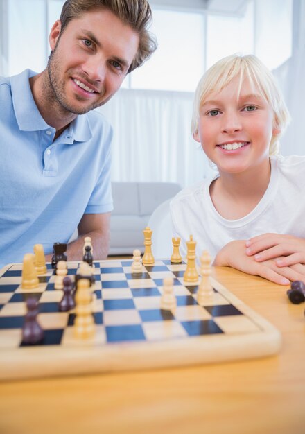 Vader die schaak met zijn kleine jongen speelt