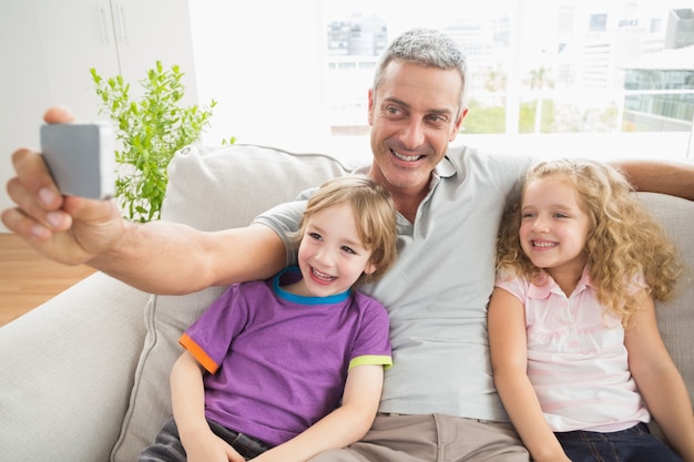 Vader die selfie met kinderen op bank neemt