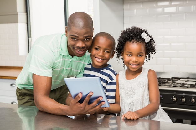 Vader die tablet met zijn kinderen in keuken gebruikt