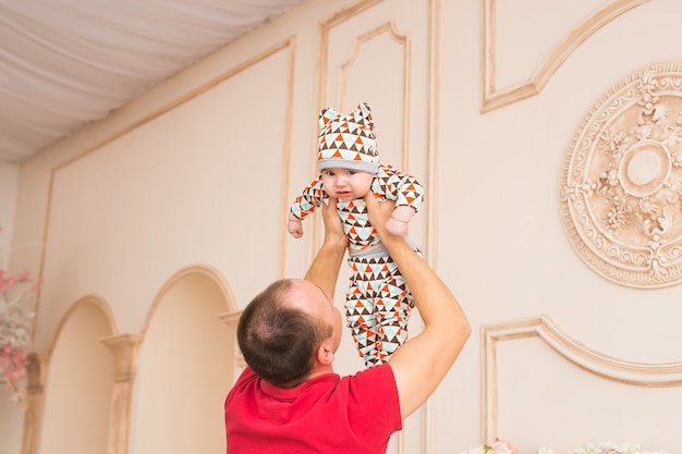 Vader die zijn kleine babykindzoon vasthoudt en speelt.