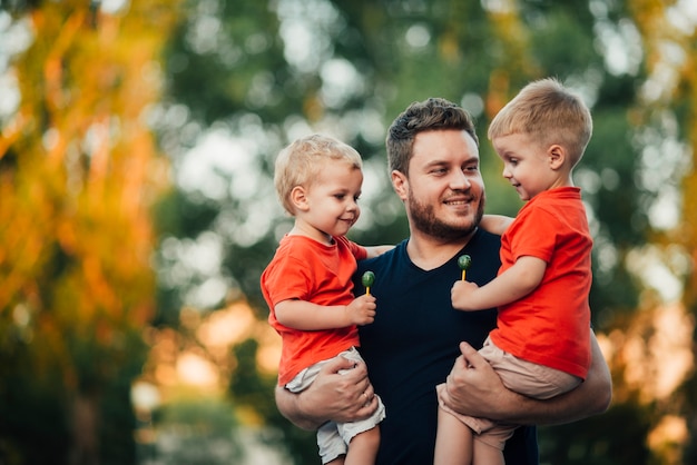 Foto vader die zijn zonen opheft met beide armen