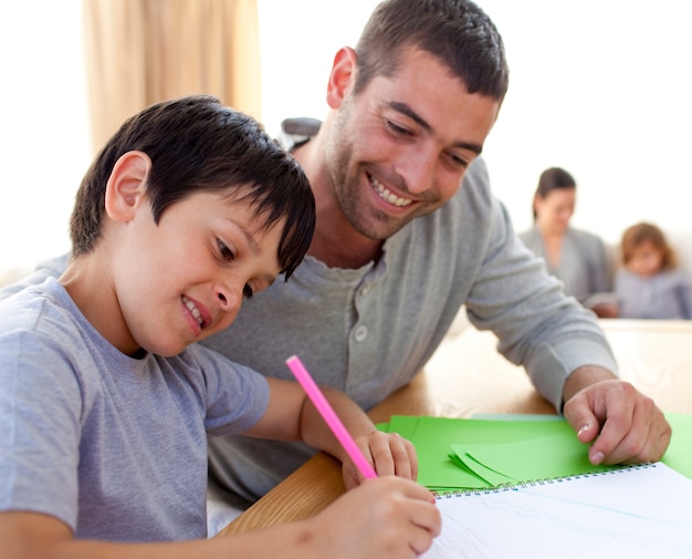 Vader die zijn zoon helpt die thuiswerk doet