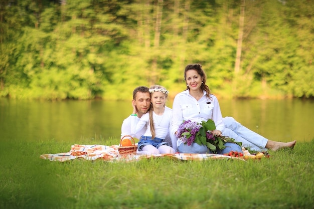 vader, dochter en een zwangere moeder op een picknick.