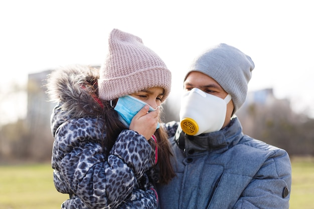 vader draagt een masker voor zijn dochtertje om het kind te beschermen tegen pm 2.5 luchtvervuiling en covid-19, concept van levensstijl van mensen in crisis van ziekte-uitbraak en luchtprobleem.