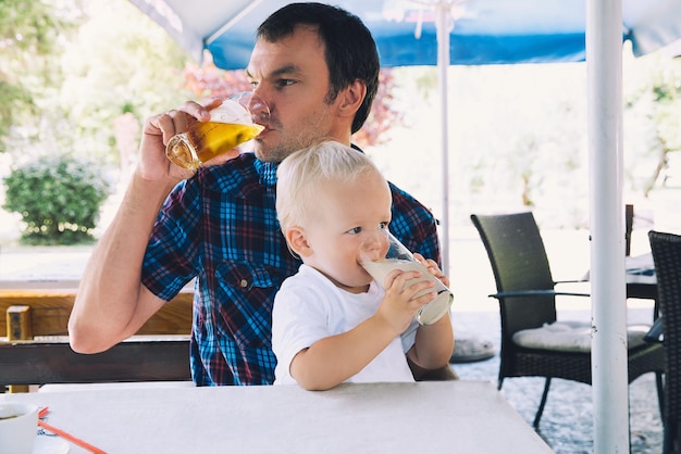 Vader drinkt bier kind drinkt sap in een strandbar vader en zoon zijn beste vrienden