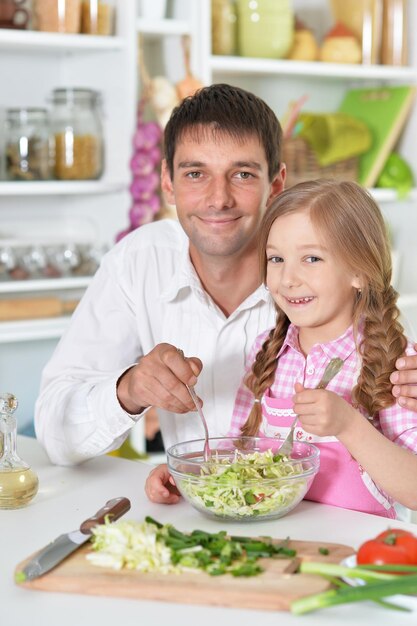 Vader en dochter bereiden samen salade op de keuken