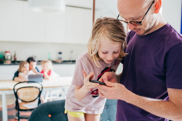 Vader en dochter binnen het gebruiken van telefoon