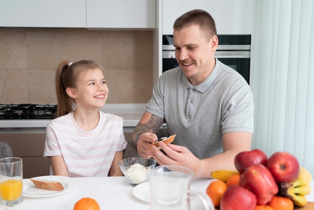 Vader en dochter die ontbijt hebben bij keuken