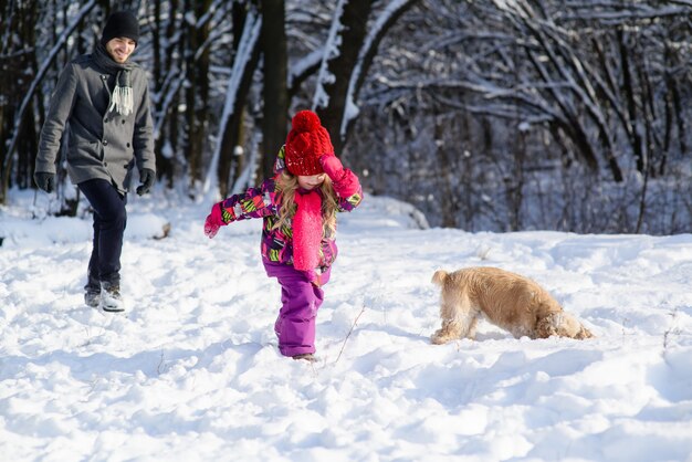 Vader en dochter en hond tijdens de winterwandeling