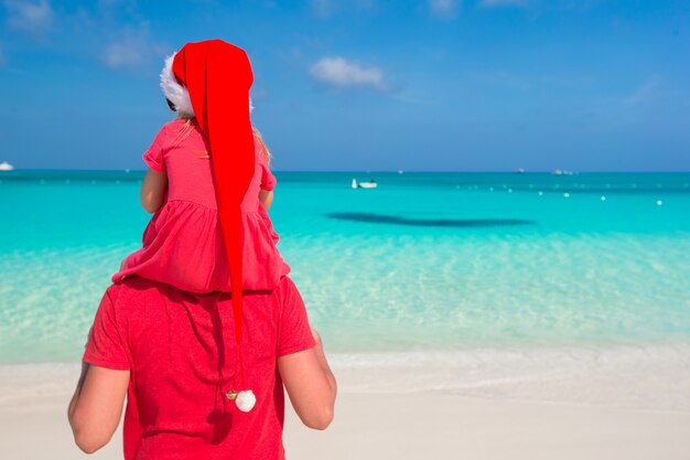 Vader en dochter in Santa Hat op tropisch strand