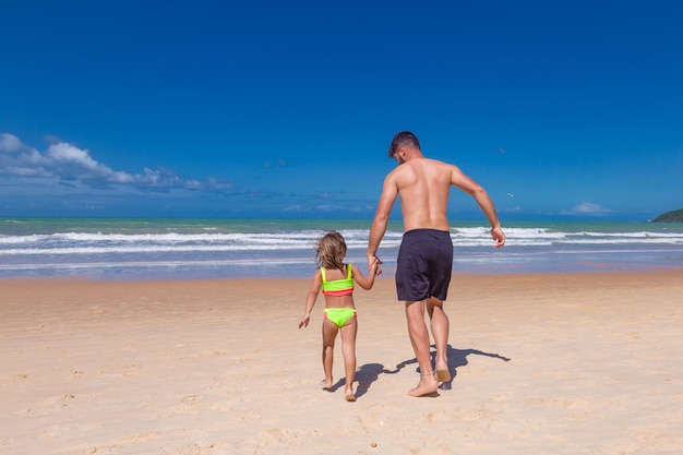 Vader en dochter op het strand op vakantie spelen en veel plezier