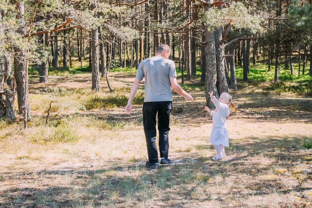 Vader en dochter spelen in een lentebos Actieve mensen vermaken zich buitenshuis