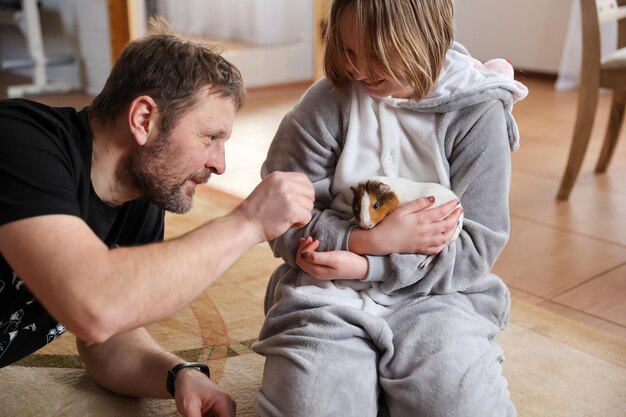 Vader en dochter spelen met cavia als huisdier