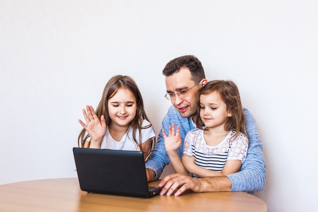 Vader en dochters communiceren via internet met hun familieleden